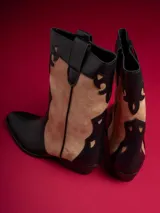 Botas de caña baja color negro con detalles en beige y cierre lateral.