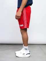 Bermuda deportiva roja con escudo del Club Nacional de Football y logo de Umbro.
