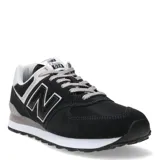 Championes urbanos New Balance modelo 574, color negro con detalles en gris y blanco. Confeccionados en una combinación de gamuza y malla, presentan el logo 'N' característico en los laterales, entresuela con tecnología ENCAP para mayor amortiguación y cierre mediante cordones.