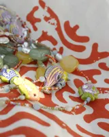 Collar corto de cuentas de colores con dije de pez de cerámica, piedras naturales y detalles en plata 925.