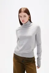 Polera de lyocell color negro, con cuello alto y ajuste al cuerpo, de manga larga.