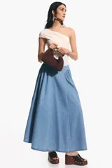 Pollera acampanada de denim color celeste, modelo largo de corte evasé con frunces en la cadera para mayor volumen.