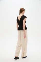 Blusa de lino color blanco, con cuello en V, pinzas de entalle y diseño al cuerpo con faldón acampanado.