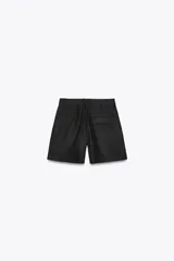 Shorts color beige confeccionados en hilatura con lino, de tiro alto. Presentan bolsillos delanteros, falsos bolsillos traseros con solapa y pinzas delanteras. Cierre frontal con cremallera y gancho metálico.