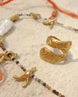 Anillo de diseño abierto con textura escamada que simula la piel de una serpiente, elaborado artesanalmente en metales nobles.