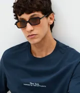 Remera de algodón azul marino con cuello redondo y mangas cortas. Presenta un diseño con estampa minimalista en el frente y una gran ilustración artística del skyline de Nueva York con la frase 'Connected by Movement' en la espalda.