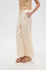 Pantalon de corte recto y tiro alto, confeccionado en viscosa de color natural, con cintura elástica y cordón ajustable.