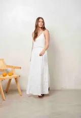 Vestido largo blanco de tirantes finos, con escote en V y detalles de inserciones de encaje broderie en la cintura y en la falda escalonada.