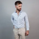 Camisa negra de algodón con cuello clásico, manga larga y cierre frontal con botones. Presenta un logo bordado en el pecho. Corte entallado.