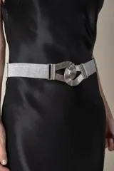 Cinto plateado de lurex elástico con hebilla metálica enlazada.