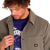 Chaqueta color verde oliva con cierre de botones a presión, dos bolsillos de parche en el pecho con logo de Caterpillar en uno de ellos y dos bolsillos laterales.