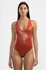 Malla enteriza color ladrillo con estampado de piel de serpiente, escote en V y espalda descubierta con tiras cruzadas unidas por un detalle metálico cuadrado.
