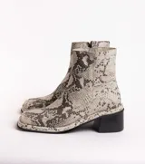 Botín de cuero con estampado de piel de serpiente en tonos blanco y negro, con puntera cuadrada y tacón bloque bajo.