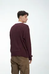 Sweater color gris claro de punto trenzado, con cuello redondo y mangas largas.