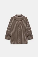 Camisa de cuello solapa con estampado de rayas verticales en tonos marrón y blanco. Presenta mangas abullonadas por debajo del codo con puños definidos y cierre frontal con botones.