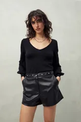 Short negro de cuero sintético con cintura con tachas metálicas.