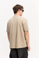 Remera oversize de manga corta, color gris, con calce amplio y estampa frontal con letras en relieve visual y marca Mistral.
