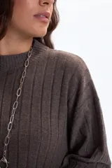 Vestido de punto marrón de manga larga, con cuello redondo y textura acanalada vertical.