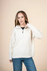 Cardigan de punto color crema, con cuello alto y cierre frontal parcial, de manga larga y diseño holgado.