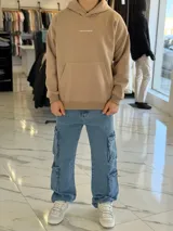 Pantalón cargo de jean azul claro, con corte oversize y múltiples bolsillos laterales en las piernas.
