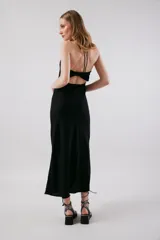 Vestido midi negro con breteles finos y escote drapeado.