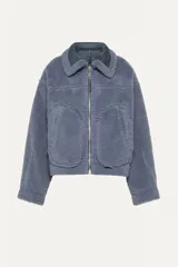 Chaqueta corta azul con efecto desgastado y cuello de piel sintética. Cuenta con cierre frontal con cremallera, dos bolsillos laterales con cremallera y puños y bajo con ribete de piel sintética.