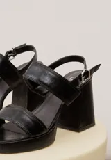 Sandalias de cuero negro con plataforma delantera, taco ancho y tira ajustable en el talón.