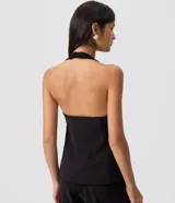 Chaleco sastrero halter negro con escote en V profundo, un botón central y bolsillos ribeteados simulados.