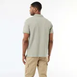 Remera polo de piqué de algodón color verde militar, con cuello clásico y cierre frontal de botones.