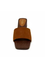 Zueco de inspiración artesanal marca Daniel Cassin, con base efecto madera y taco bajo. Presenta una capellada ancha de color negro con detalles de tachas metálicas doradas en los laterales.