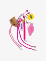 Llavero con dijes que incluyen un gato de peluche color marrón, una cinta métrica amarilla, un dije rosa con texto y cordones rosas y fucsias.