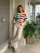 Sweater de lana merino con estampado Fair Isle en tonos azul marino, beige, naranja, verde oliva y bordó. Tiene cuello redondo y mangas largas.