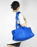 Bolso tipo tote color beige con diseño acolchado y doble asa de hombro.