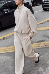 Pantalón de tiro alto con pernera recta y nervio marcado en el delantero. Cuenta con cintura elástica en la parte posterior, bolsillos delanteros y bolsillos de plastrón en la parte trasera. Cierre frontal con botón interior y ganchos.