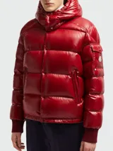 Campera puffer Moncler modelo Maljasset, de color rojo brillante, con capucha integrada, cierre frontal con botones a presión, bolsillos laterales con cierre y bolsillo pequeño en la manga con logo de la marca.