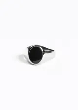 Anillo plateado de acero quirúrgico con piedra negra sintética.