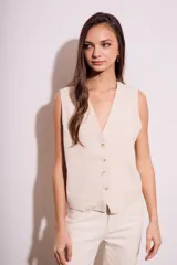 Chaleco de corte sastre con escote en V y cierre frontal de botones. Presenta un diseño sin mangas, entallado al cuerpo, confeccionado en una mezcla de lino y viscosa.