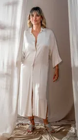 Vestido camisero largo color blanco, con cuello clásico, mangas 3/4 y abertura frontal con botones.