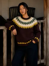 Buzo de lana merino con diseño nórdico, de base color borgoña oscuro con detalles geométricos en crudo, verde bosque y mostaza en el cuello y los puños.