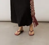 Sandalia tipo chancleta de dedo color rojo oscuro con acabado brillante, de diseño minimalista.