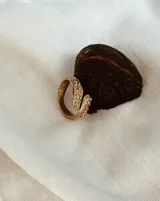 Anillo abierto de diseño orgánico con textura irregular y acabado brillante, realizado artesanalmente en metal.