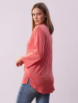 Blusa Ninety color beige con textura, cuello base con escote en V y abertura central con botones. Tiene un bolsillo en el pecho y mangas 3/4 regulables con presilla y botón.