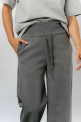 Pantalón blanco de silueta amplia y caída fluida, con cintura alta elastizada y lazo regulable con terminaciones metálicas.