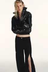 Jeans de corte baggy y tiro medio en color negro. Presenta diseño de cinco bolsillos y detalle de cremalleras verticales en el frente de las piernas con efecto torcido.