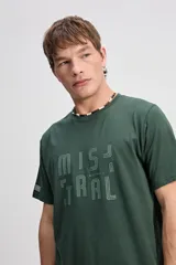 Remera de manga corta color verde oscuro, con estampa frontal de la marca Mistral y detalle de etiqueta en la manga.