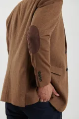 Saco de vestir marrón de corte clásico, con solapas de muesca, cierre de dos botones, bolsillo en el pecho y bolsillos laterales con solapa.