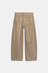 Pantalón de tiro medio en color marrón con diseño de animal print y aplicaciones de brillos en contraste. Cuenta con cinco bolsillos, presillas para cinturón y cierre frontal con cremallera y botón metálico.