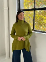 Sweater de punto color verde pistacho, con cuello alto tipo polera, mangas largas y diseño holgado con costuras verticales decorativas.