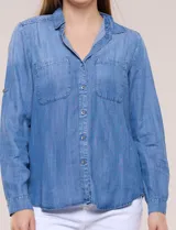 Camisa confeccionada en tela tencel azul, de estilo casual y silueta semi holgada. Presenta cuello camisero tradicional, abotonadura frontal completa, dos bolsillos superiores en el pecho y mangas largas con presilla y botón para arremangar.
