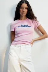 Remera rosa de manga corta y cuello redondo, con el texto "Expert Overthinker" estampado en azul en el centro del pecho.
